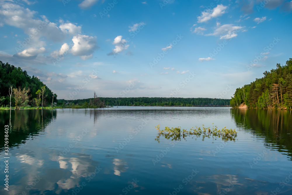 Russia, Moscow region, Dzerzhinsky - forest lake in the evening. Reflection clouds in lake.