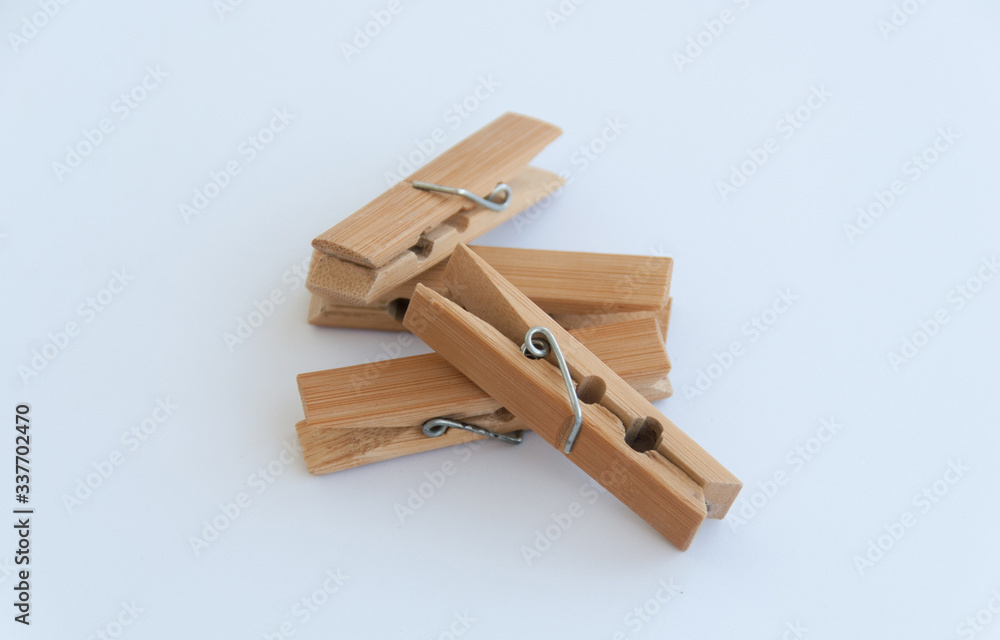 Several wooden clothes pins lying on each other on a white background. Close up Several wooden clothes pins lying on each other on a white background. Close up