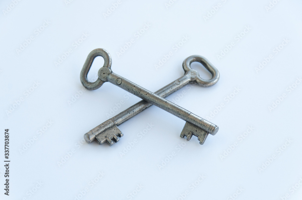 Two crossed retro keys isolated on white background. Metal, silver coloured, rusty door keys crossed Two crossed retro keys isolated on white background. Metal, silver coloured, rusty door keys crossed