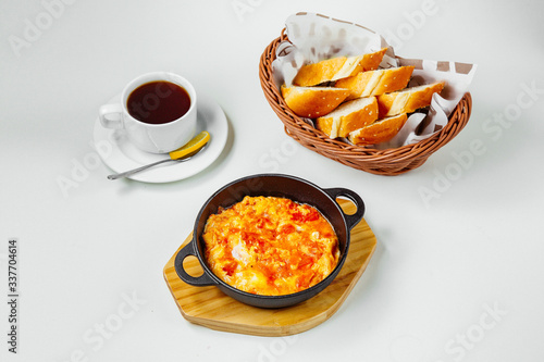 breakfast setup with egg and tomato dish black tea and bread