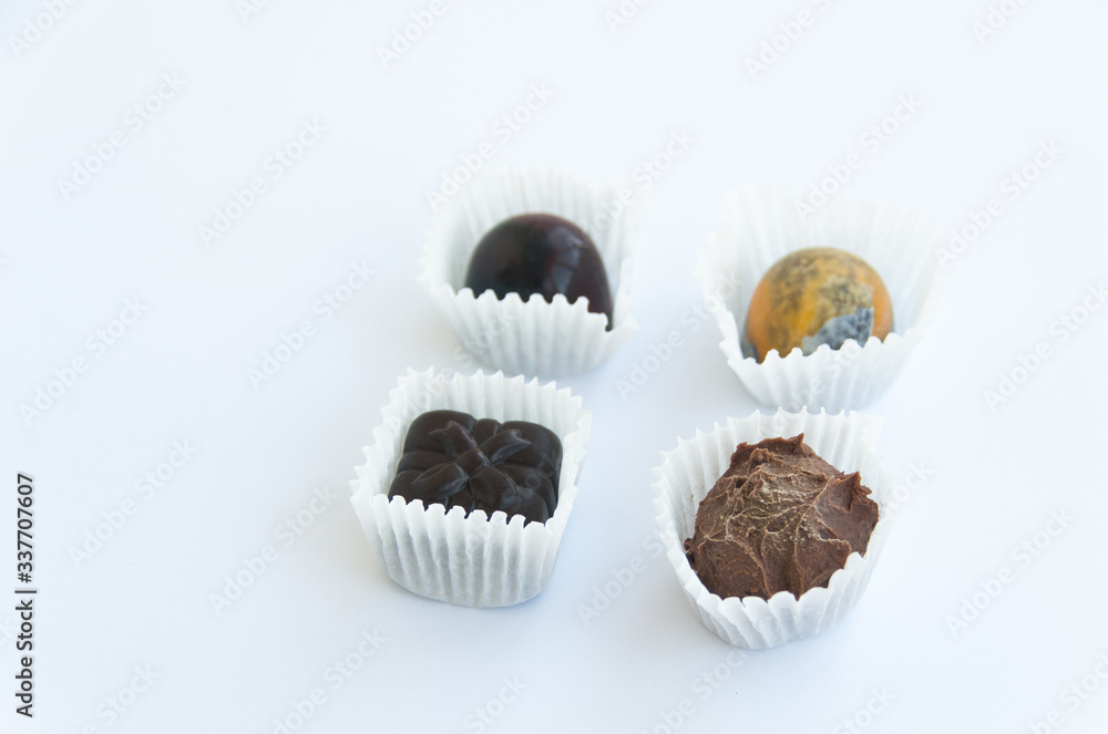 Four handmade chocolate sweets isolated on a white background. Close up Four handmade chocolate sweets isolated on a white background. Close up