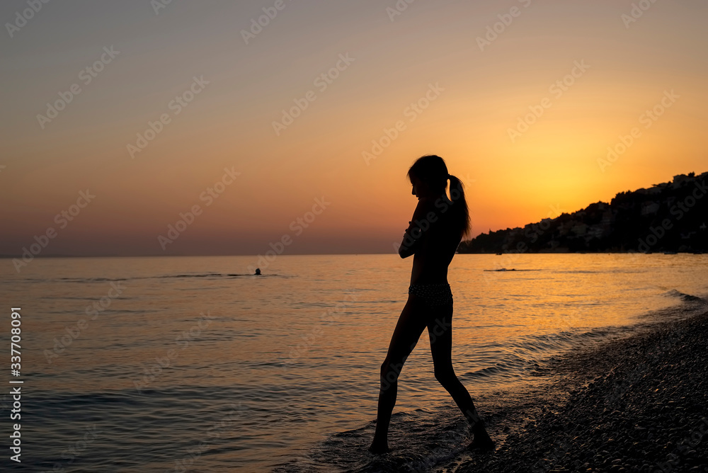 Mädchen im Sonnenuntergang am Strand