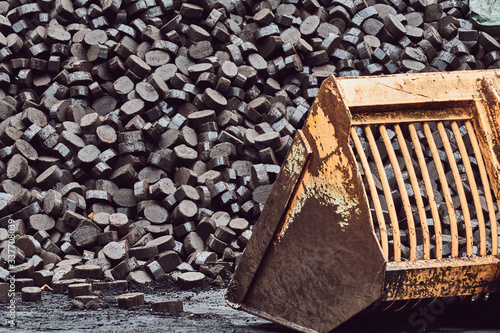 excavator shovel in front of coal mountain