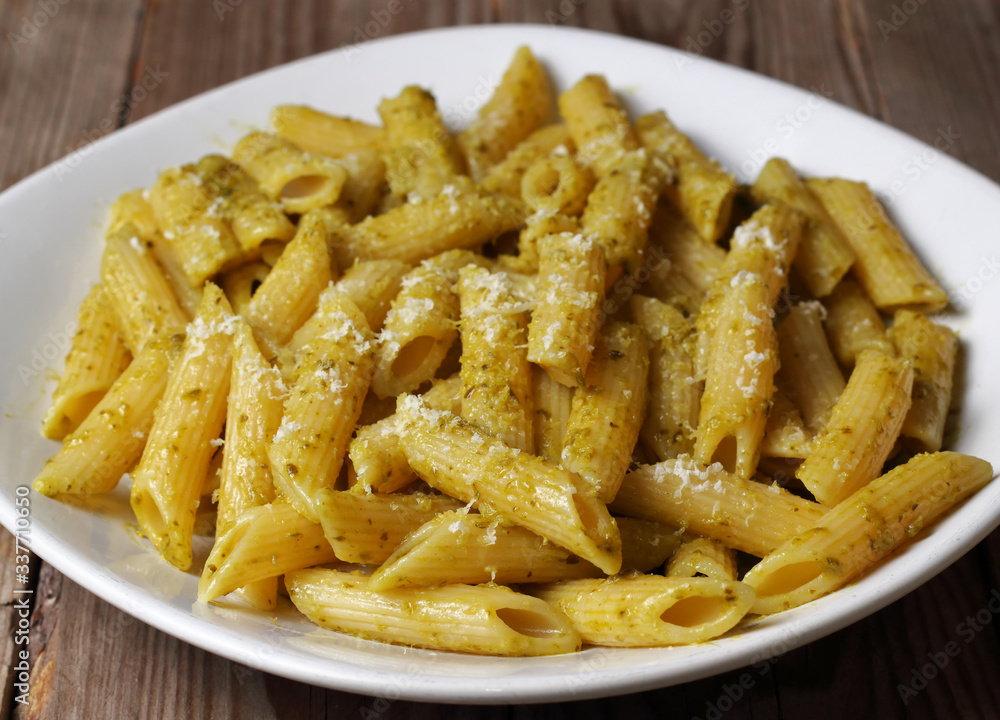 Penne rigate condite con pesto di basilico tipico della cucina tradizionale ligure. Pasta italiana. Penne rigate condite con pesto di basilico tipico della cucina tradizionale ligure. Pasta italiana.