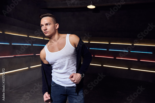 man against the background of neon lights in a white t-shirt casual posing