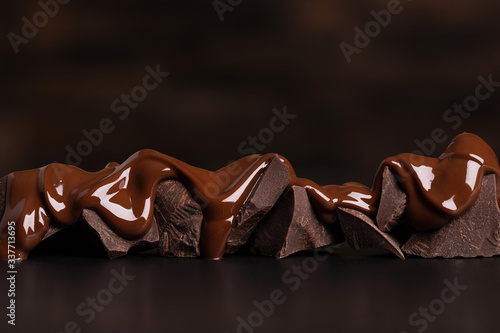 melted chocolate covers the pieces. delicious dessert on black table