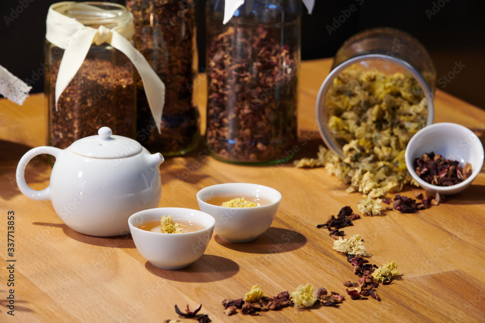 Chrysanthemum tea in Chinese teapot cups; focus on tea