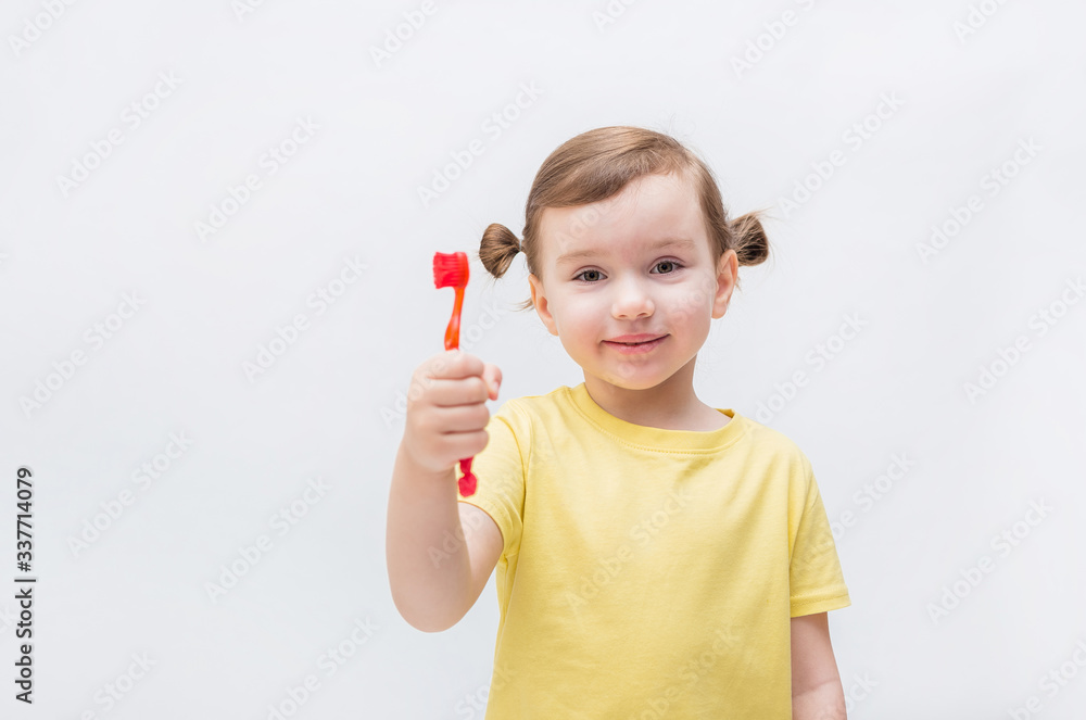 The girl brushes her teeth with a toothbrush. Tooth decay. It's a problem with teeth. Toothache. Blonde girl in a white background in a yellow t shirt The girl brushes her teeth with a toothbrush. Tooth decay. It's a problem with teeth. Toothache. Blonde girl in a white background in a yellow t shirt