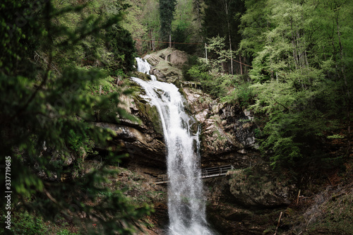 Wasserfall in einem Wald mit einer Brücke