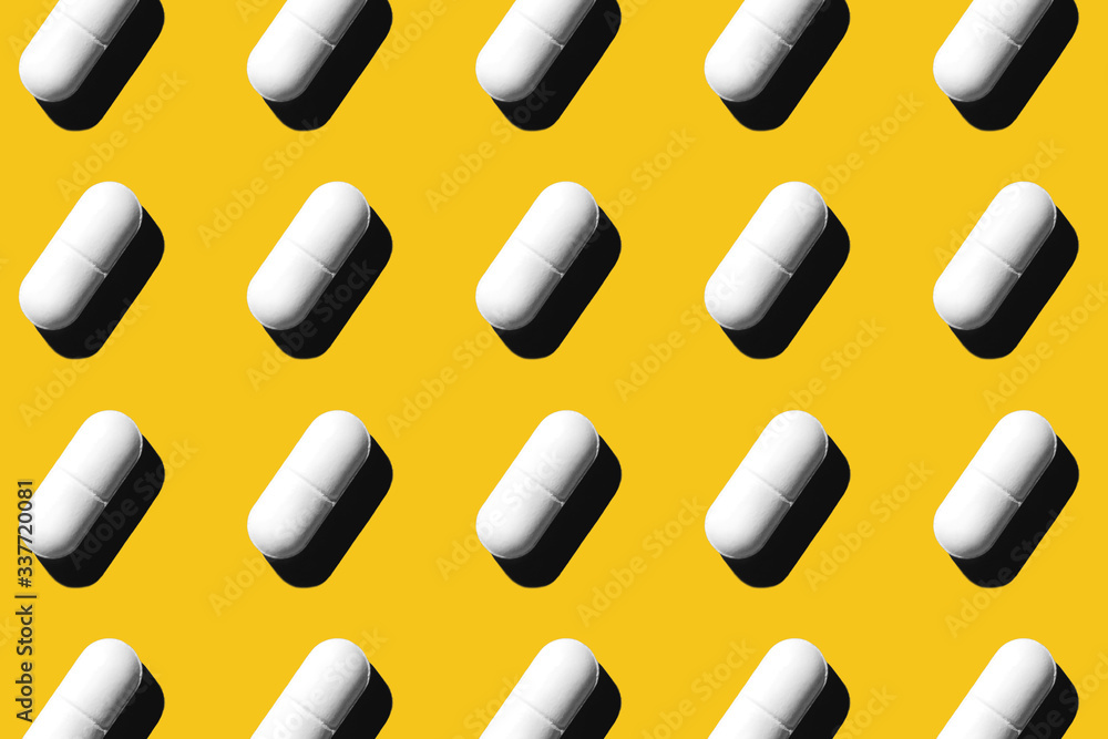 Trendy pattern made with Pharmaceutical medicine white pills on yellow background. Medicine creative concepts. Minimal style with colorful paper backdrop. Trendy color of the year 2020. Trendy pattern made with Pharmaceutical medicine white pills on yellow background. Medicine creative concepts. Minimal style with colorful paper backdrop. Trendy color of the year 2020.