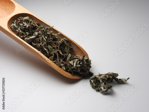 High angle view of dry mugwort on spoon isolated on white background.  Be used to ward off evil spirits and to drive away mosquitoes during the Dragon Boat Festival in Taiwan. Chinese herbal medicine.
