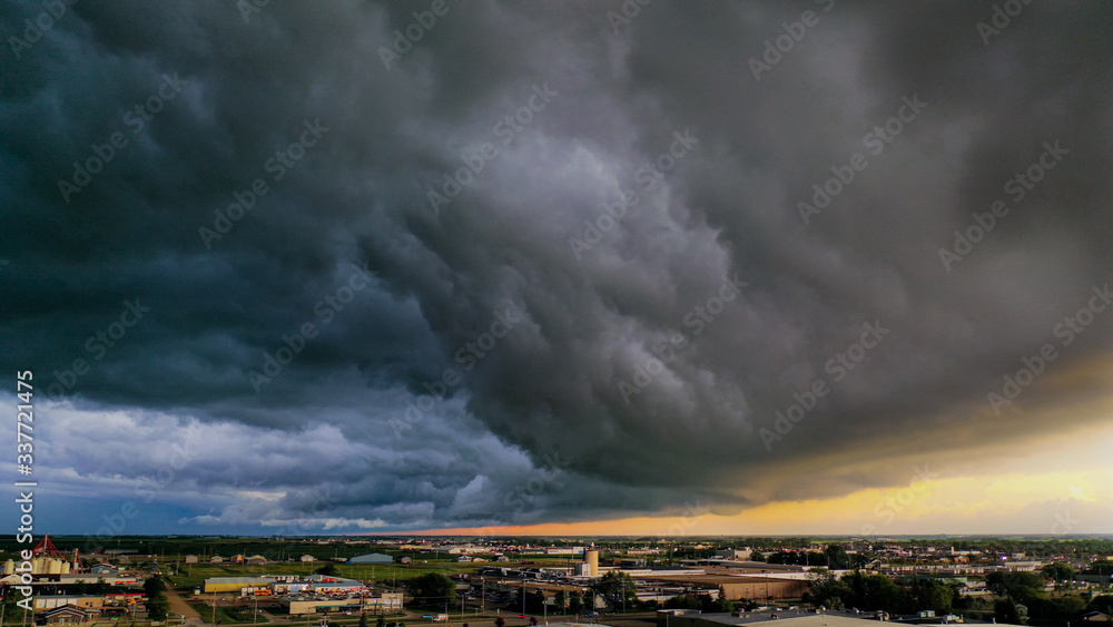 A large weather system rolls over small prairie city revealing magnificent colors in the sky. A large weather system rolls over small prairie city revealing magnificent colors in the sky.