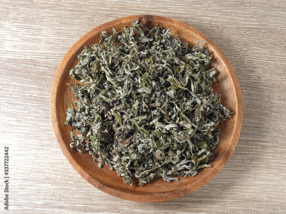 Top view of dry mugwort on wooden plate. Chinese medicine. During the Dragon Boat Festival, is usually hung on the door, which is used to ward off evil spirits and to drive away mosquitoes. Top view of dry mugwort on wooden plate. Chinese medicine. During the Dragon Boat Festival, is usually hung on the door, which is used to ward off evil spirits and to drive away mosquitoes.