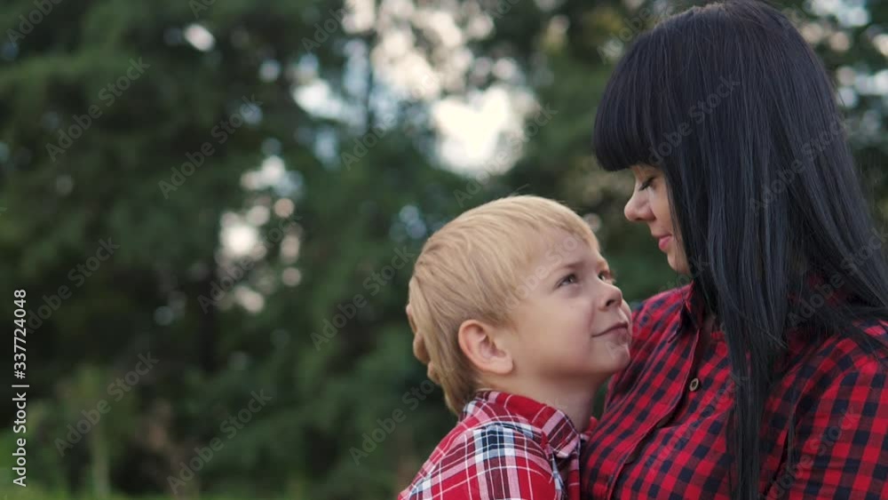happy family mom and son concept lifestyle . mom tender childhood video . slow motion video . mom a brunette girl gently hugs takes care of the boy son blonde outdoors happy family mom and son concept lifestyle . mom tender childhood video . slow motion video . mom a brunette girl gently hugs takes care of the boy son blonde outdoors