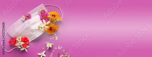 medical mask flowers on top with diffrent colors spring flowers on pink background top view with place for text.Coronavirus quarantin concept © Алина Битта
