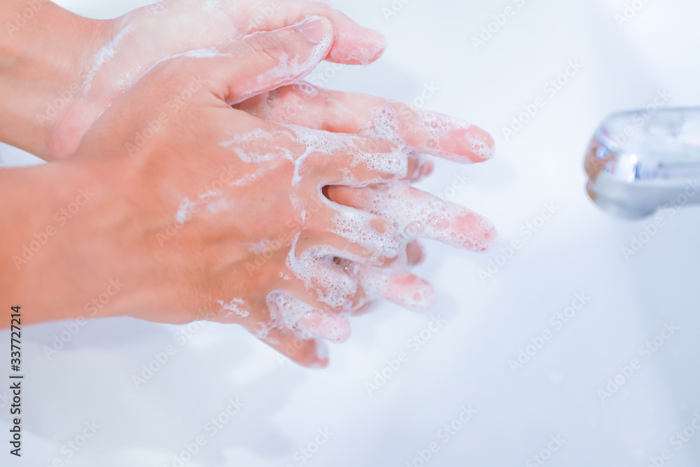 young women washing hands with soap rubbing fingers and skin on white basin young women washing hands with soap rubbing fingers and skin on white basin