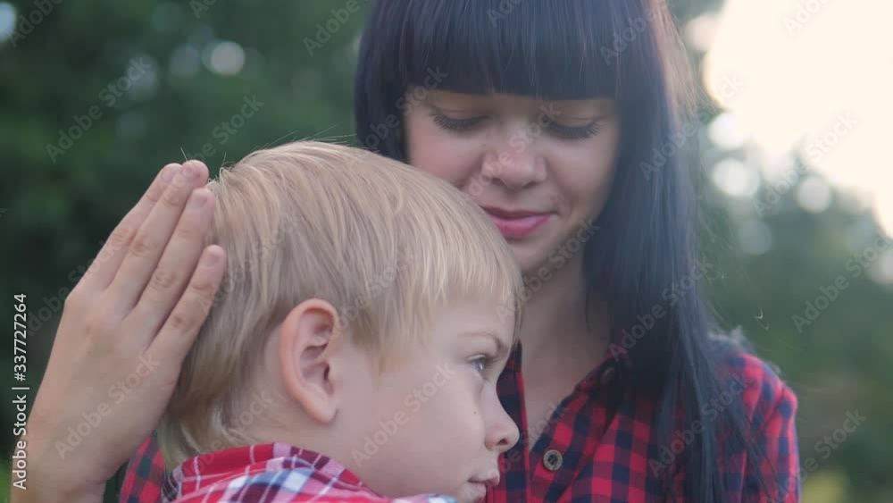 happy family mom and son sad child concept. mom tender childhood video. slow motion video. a mom brunette girl protects caress gently hugs lifestyle takes care of the son boy blonde outdoors happy family mom and son sad child concept. mom tender childhood video. slow motion video. a mom brunette girl protects caress gently hugs lifestyle takes care of the son boy blonde outdoors