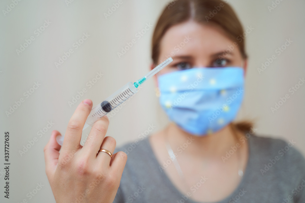 girl in a protective mask of European Union with a syringe in her hand girl in a protective mask of European Union with a syringe in her hand