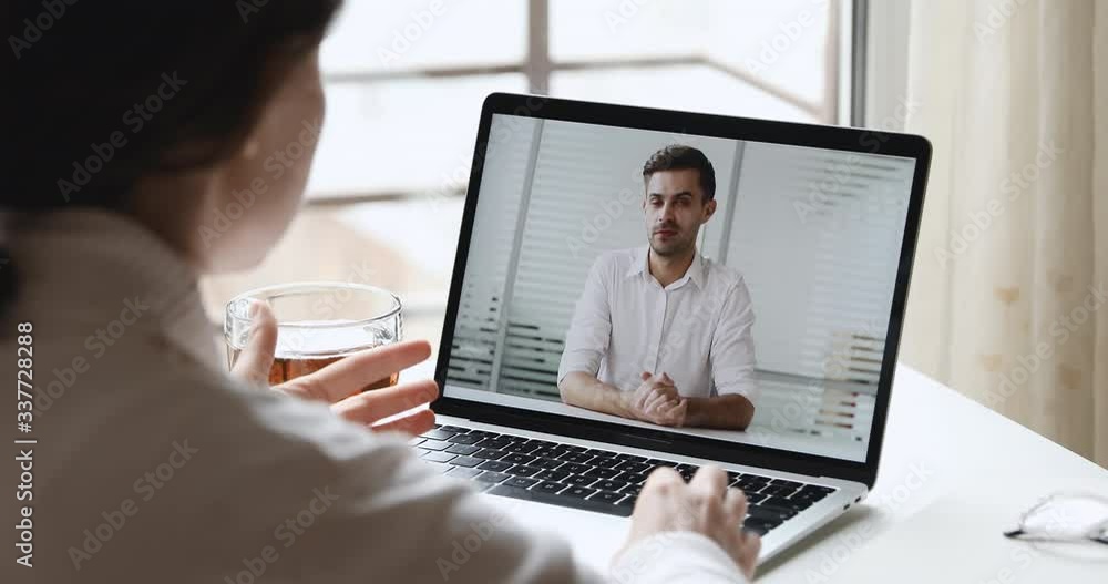 Webcam business meeting concept. Female employee using computer app making video call discussing distance work from home office with executive manager. Online job interview. Over shoulder screen view Webcam business meeting concept. Female employee using computer app making video call discussing distance work from home office with executive manager. Online job interview. Over shoulder screen view