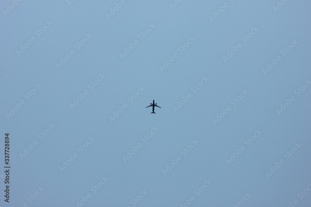 a plane flying alone in the clear morning sky