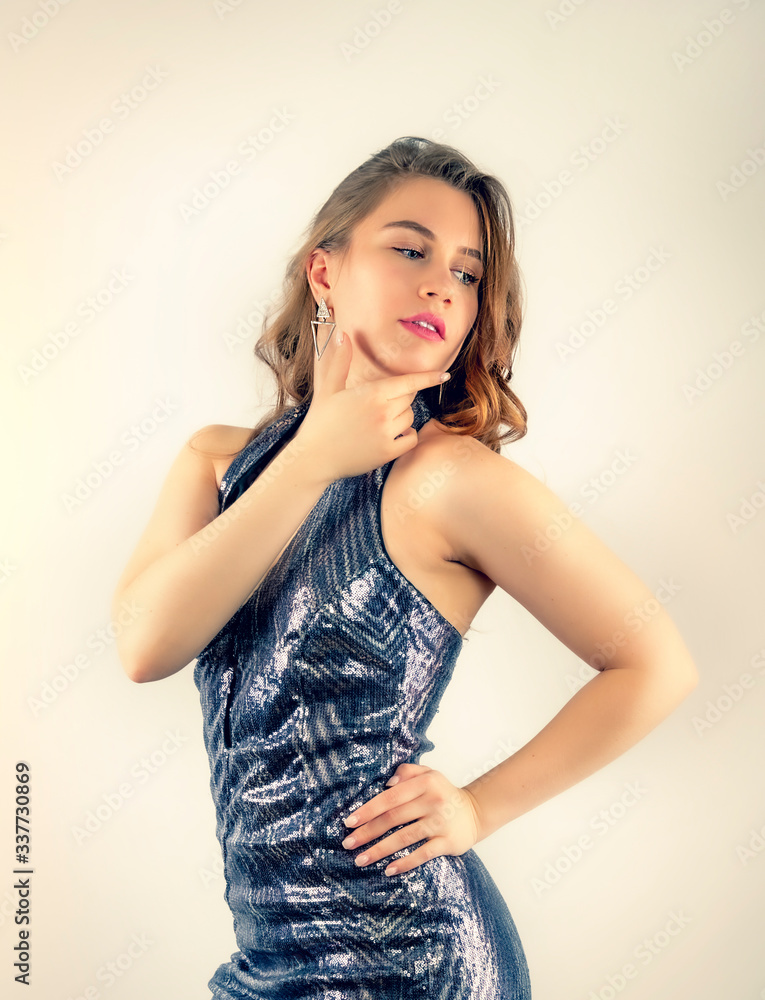 Beautiful woman with a sexy slim body. Beautiful stunning girl with curly hairstyle. Portrait of beautiful woman with a long hair. Fashion model. Gorgeous sensual woman in a silver shiny dress. Beautiful woman with a sexy slim body. Beautiful stunning girl with curly hairstyle. Portrait of beautiful woman with a long hair. Fashion model. Gorgeous sensual woman in a silver shiny dress.