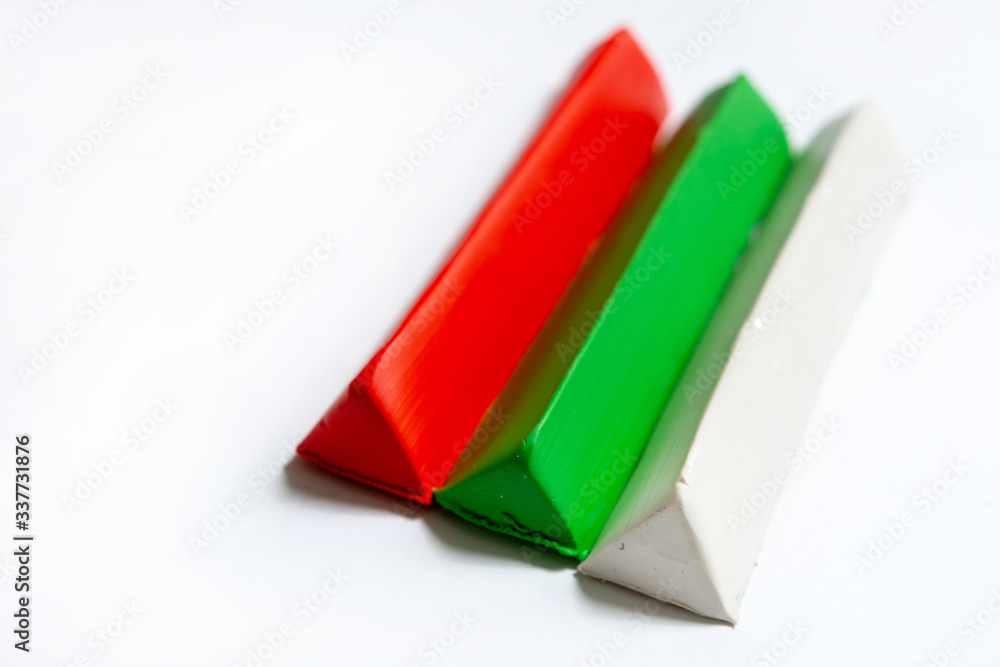Fototapeta premium Three multi-colored plasticine bars on a white background. material for children's creativity. isolate.