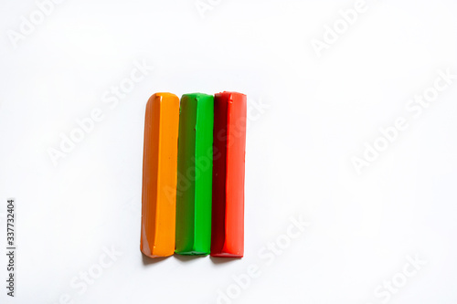 Three multi-colored plasticine bars on a white background. material for children's creativity. isolate.