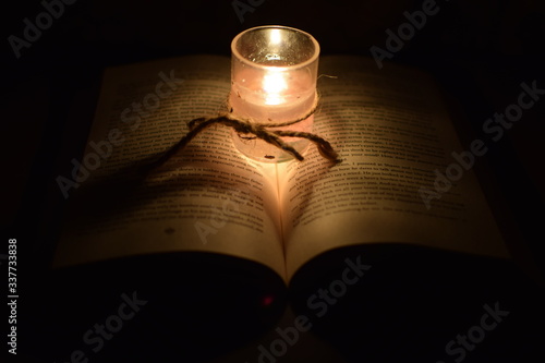 candle lighting the words on the book, background image