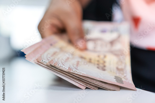 Foto Weak baht, Thai baht banknotes, Businessman's hands counting money