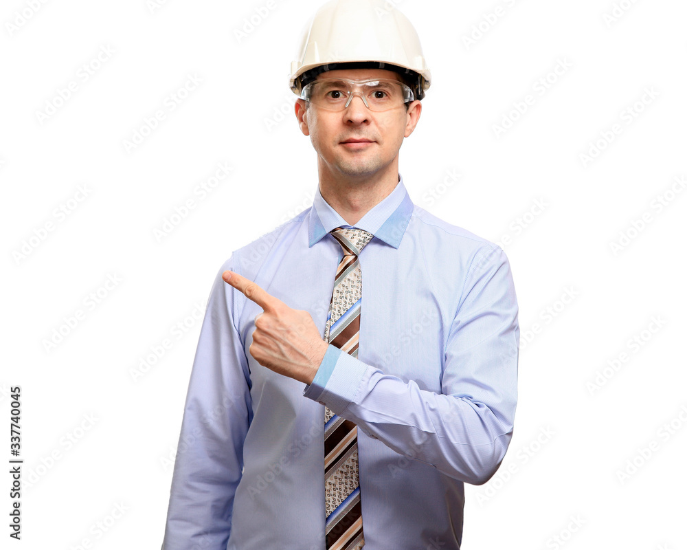 A hilarious man is engineered in a construction helmet, glasses, shirt and tie shows a finger to the side. Isolated A hilarious man is engineered in a construction helmet, glasses, shirt and tie shows a finger to the side. Isolated