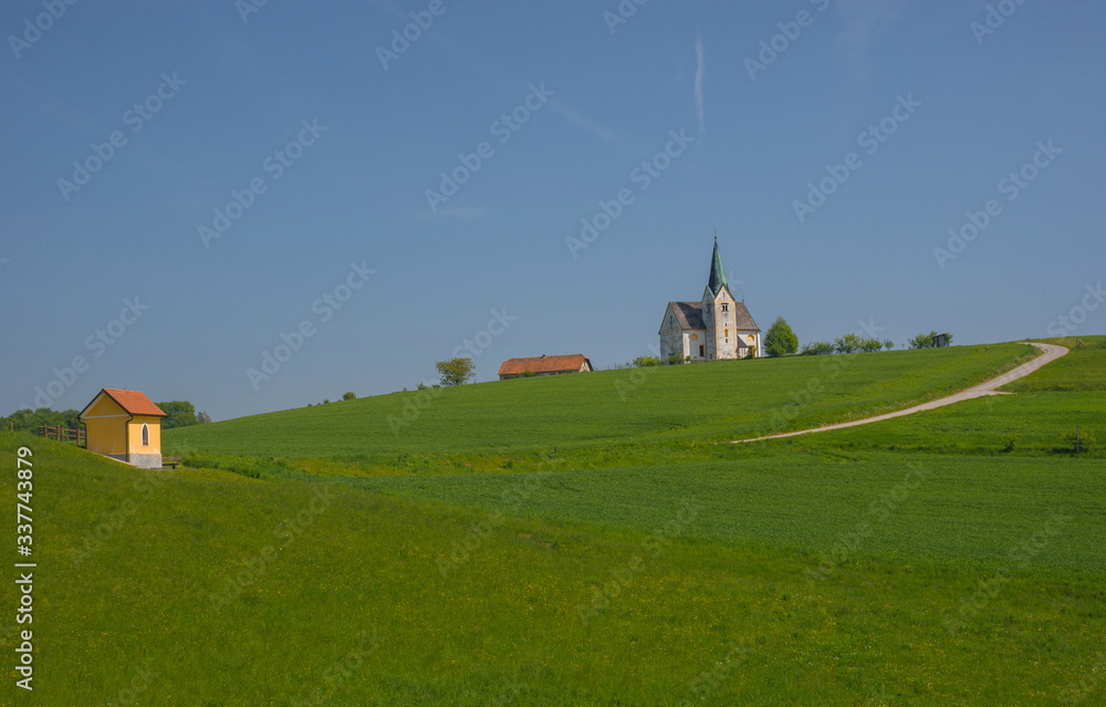 Slovenian countryside in spring with charming little church on a hill, in Slovenia