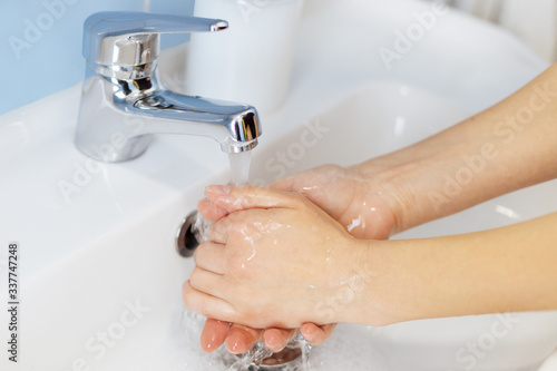Soap in the hands of a girl. Hand washing