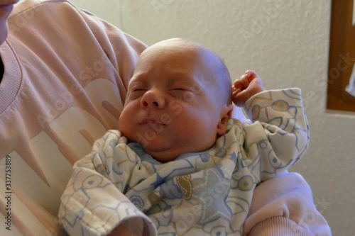 a baby is sleeping in the hands photo