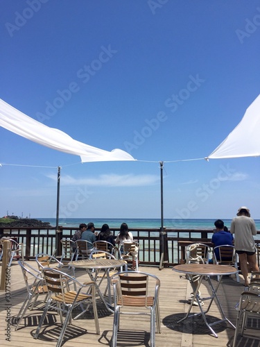 White Long Curtain Interior Design in the cafe around the beach into blue sky © HaedunJu