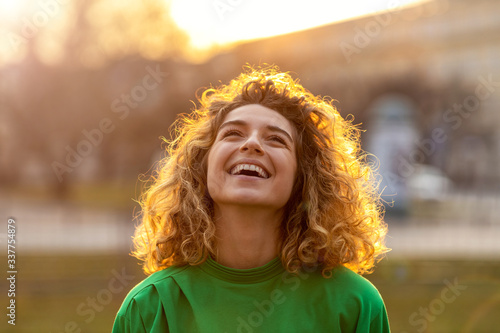 Obraz na płótnie Portrait of young woman with curly hair in the city