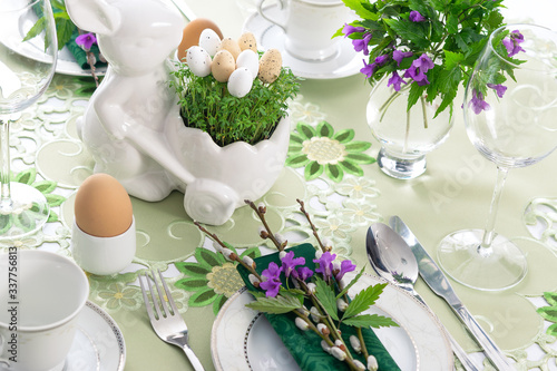 Fotografie Elegant Easter holiday table settings decoration with fresh early spring violet flowers, cress leaves and eggs