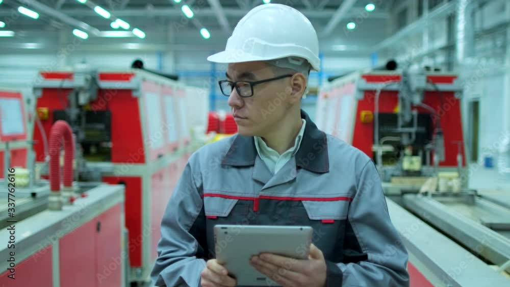 Asian, chinese Korean professional male engineer man business people in hard hat working on engineering industrial manufacturing facility using tablet indoors, worker architect inspection. slow-mo 4 K Asian, chinese Korean professional male engineer man business people in hard hat working on engineering industrial manufacturing facility using tablet indoors, worker architect inspection. slow-mo 4 K