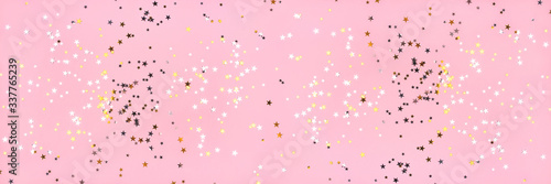 Golden and silver stars on pink pastel background. Flat lay, top view.