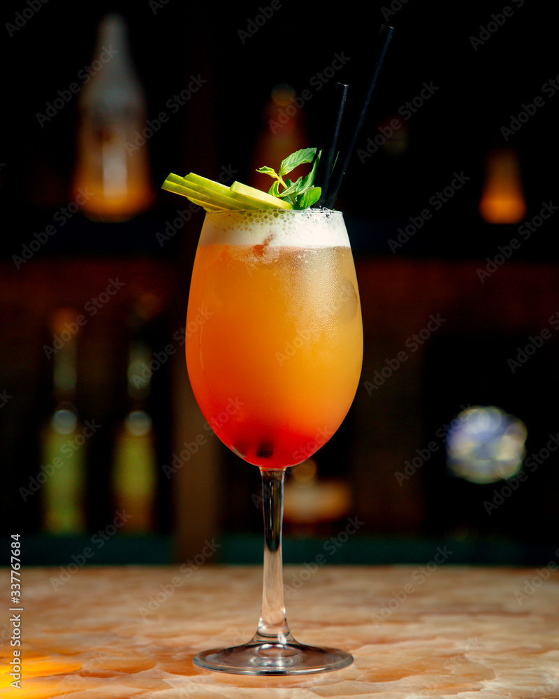 Φωτογραφία a glass of orange cocktail garnished with mint and green apple slices