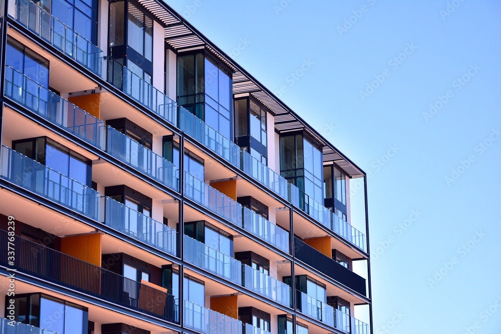 Modern and new apartment building on a sunny day with a blue sky. Contemporary residential building exterior in the daylight.