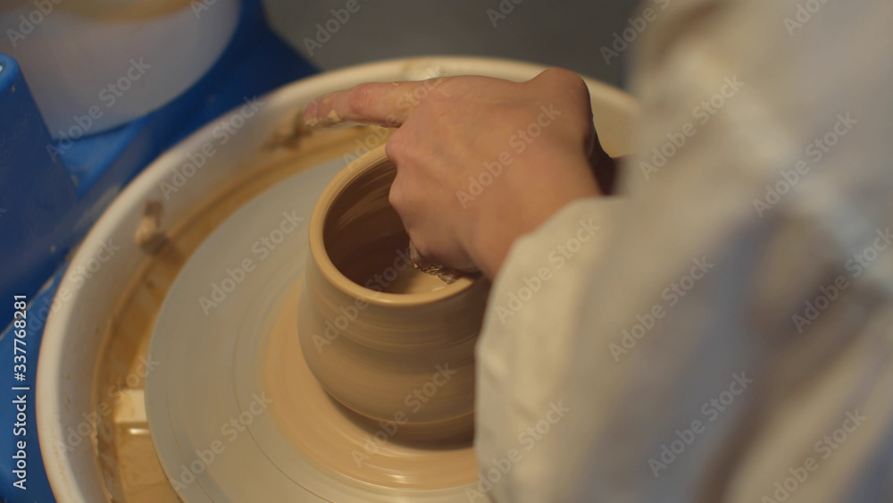Fototapeta premium Pottery craftsmanship. Girl makes a handmade vase