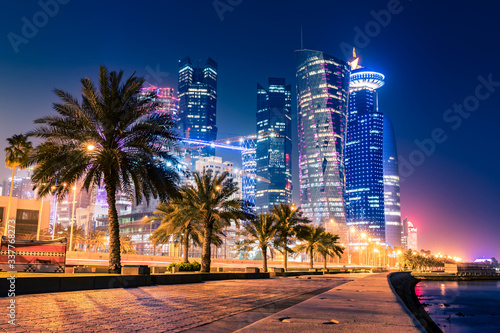 Night view on the centre of the city Doha, Qatar with many modern luxury building and skyscrapers illuminated with bright lights. photo