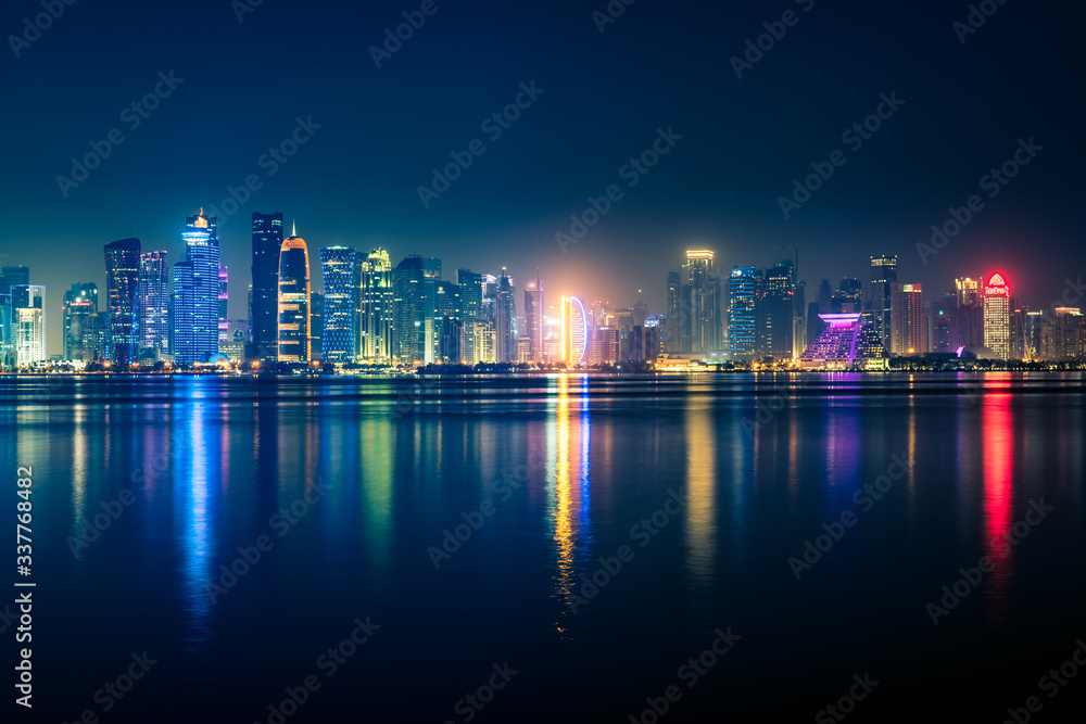 Night view on the centre of the city Doha, Qatar with many modern luxury building and skyscrapers illuminated with bright lights. Night view on the centre of the city Doha, Qatar with many modern luxury building and skyscrapers illuminated with bright lights.
