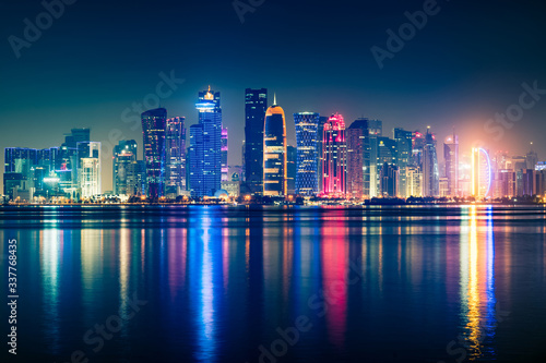 Night view on the centre of the city Doha  Qatar with many modern luxury building and skyscrapers illuminated with bright lights.