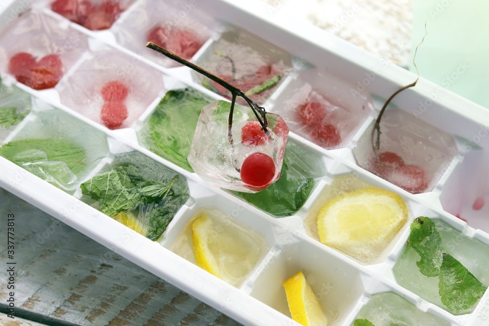 Ice cubes with mint, lemon and red berries in a tray for making drinks, dessert, healthy food
Ice cubes with mint, lemon and red berries in a tray for making drinks, dessert, healthy food