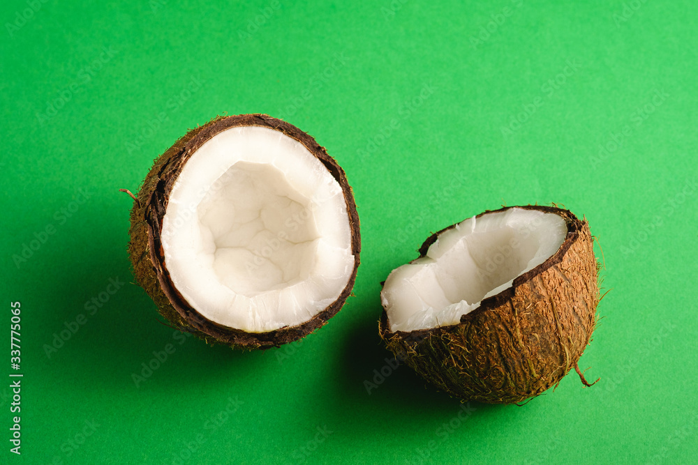 Coconut fruits on green plain background, abstract food tropical concept, angle view Coconut fruits on green plain background, abstract food tropical concept, angle view