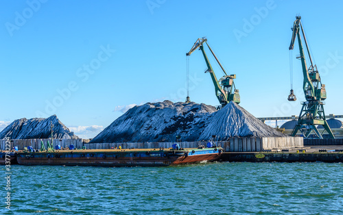 Cranes and piles of coal in a coal port in Gdynia, Poland.