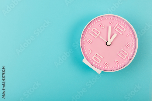 Pink clock on a green background