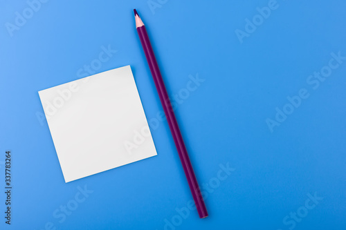 Pencil and a piece of paper on a blue background