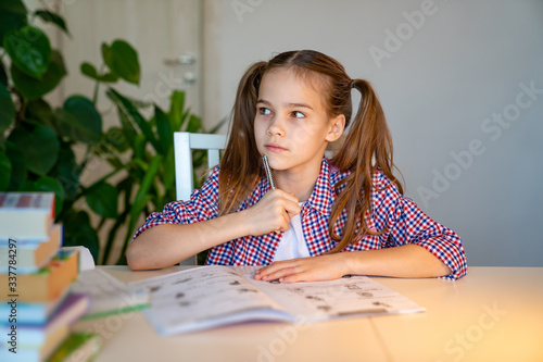 teenager girl in a plaid shirt doing homework